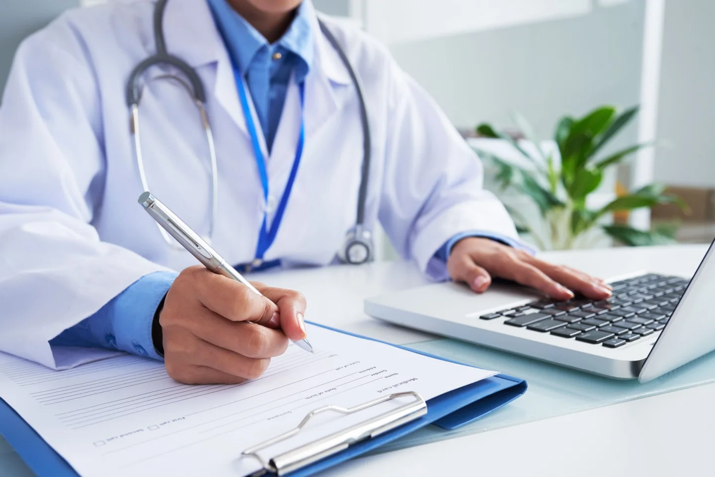 Médico preenchendo formulário clínico em computador
